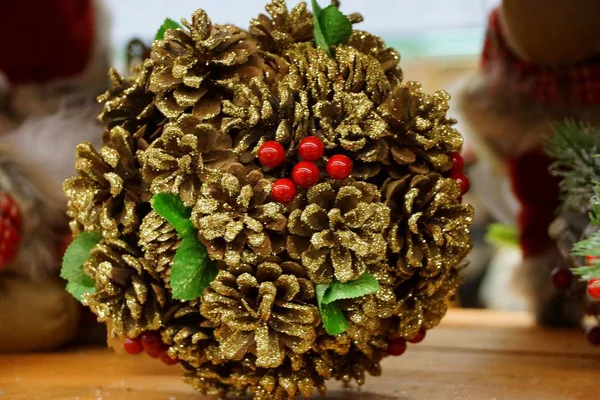 Weihnachtskugel Aus Braunen Zapfen Und Roten Beeren Auf Dem Tisch — Stockfoto