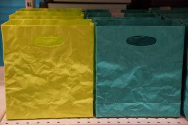 raf üzerinde sarı ve yeşil renkteki iki plastik torbalar