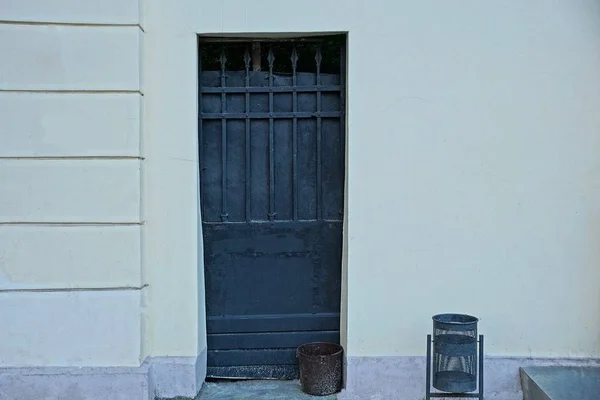 Oude Zwarte Ijzeren Deur Een Grijze Betonnen Wand — Stockfoto