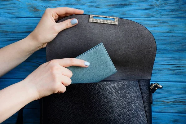 Kadın el bir siyah deri çanta gri bir defterde yatıyor