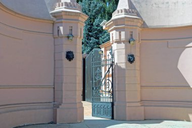 dövme deseni ve kahverengi Beton çit ile siyah demir kapıları açın