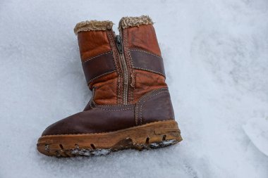 bir eski kahverengi kış çizme ile fermuar üstünde beyaz kar dışında