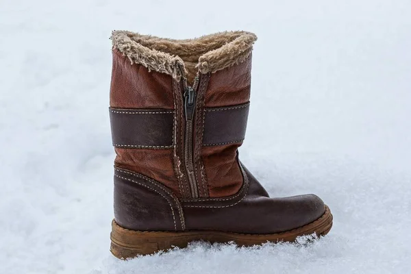 在白雪上拉链的老棕色冬天靴子 — 图库照片