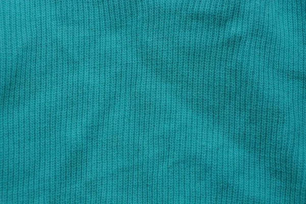 green background of fabric from a piece of crumpled clothes
