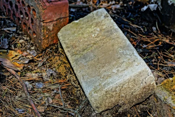 old gray brick laying on the ground outside