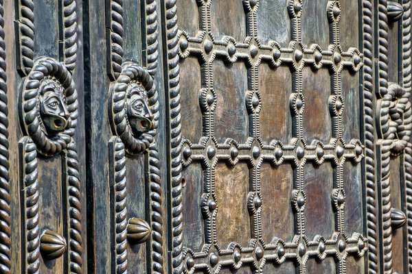The texture of iron and a fragment of old doors with a pattern