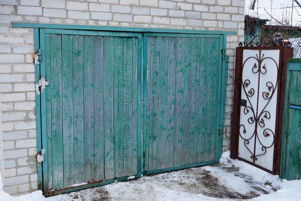 Фасад Серого Кирпичного Гаража Зелеными Деревянными Воротами Снаружи Снегу — стоковое фото