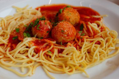 Spagetti sosları ve beyaz bir plaka üzerinde yuvarlak köfte ile