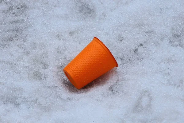 Oranje Plastic Beker Nest Liggen Witte Sneeuw Buiten — Stockfoto