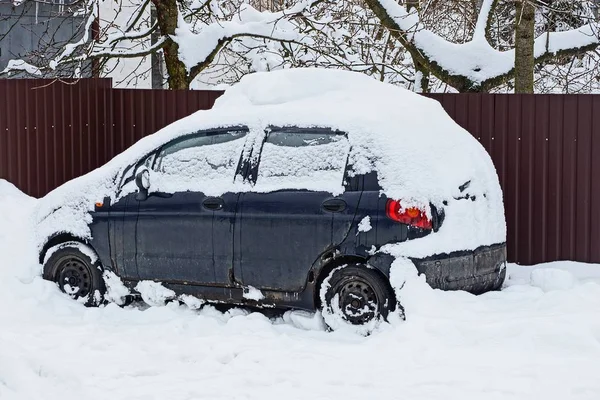 Niebieski Samochód Zaspie Śniegu Biało Ulicy Pobliżu Ogrodzenia — Zdjęcie stockowe