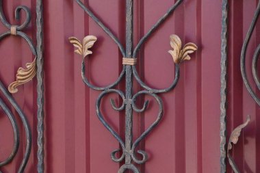 Kapıda siyah kırmızı metal desen var.