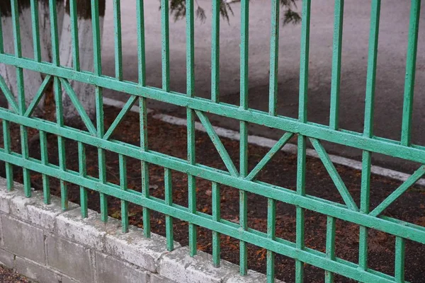 绿色铁棒的金属栅栏的一部分在一个模式 — 图库照片
