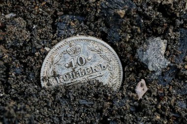 bir beyaz eski gümüş sikke siyah Earth'te yatıyor