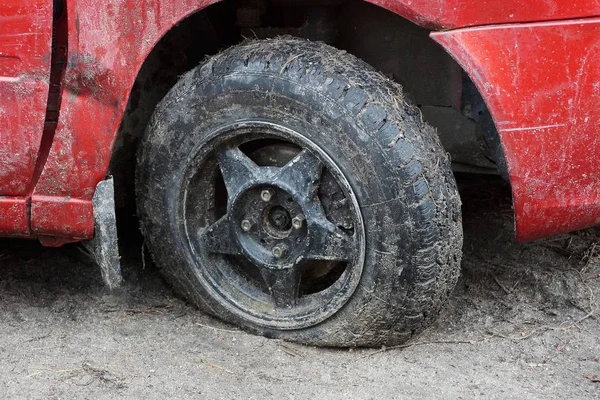 Een Zwarte Lekke Band Van Een Rode Auto Een Onverharde — Stockfoto