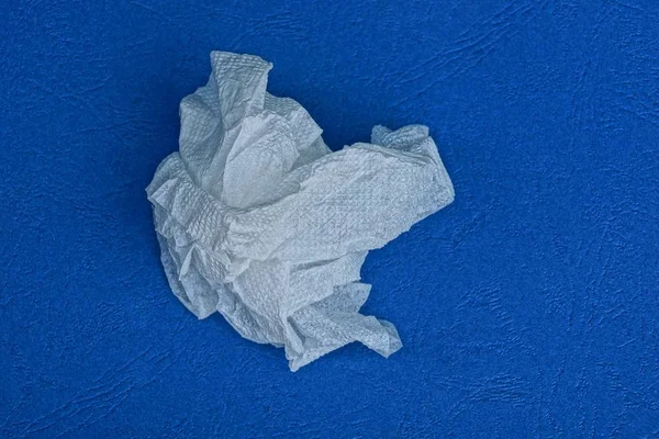 Pedazo Hoja Papel Blanco Arrugado Yace Sobre Una Mesa Azul — Foto de Stock