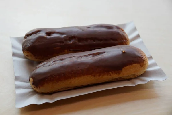 Zwei Braune Schokoladen Choux Gebäck Auf Einem Grauen Pappteller — Stockfoto