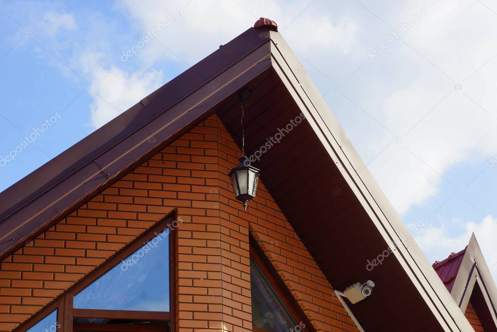 brown brick attic with a window and a lantern against the sky