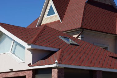 Kırmızı kiremit mavi gökyüzüne karşı bir pencere ile tavan çatı