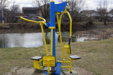 Rıhtımlar üzerinde yeşil çim Caddesi üzerinde renkli metal spor simülatörü