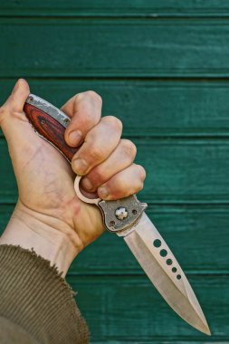 Yeşil duvar karşı sıkı bir elinde Avcılık Bıçak