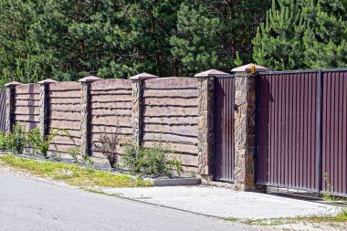 Gri kahverengi kapı ve asfalt yolun önünde bir çit