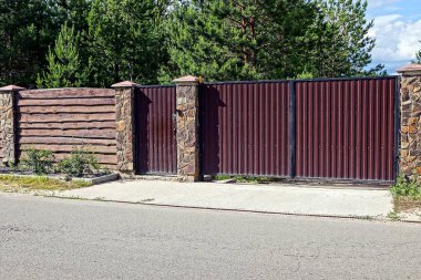 Gri kahverengi kapı ve asfalt yolun önünde bir çit
