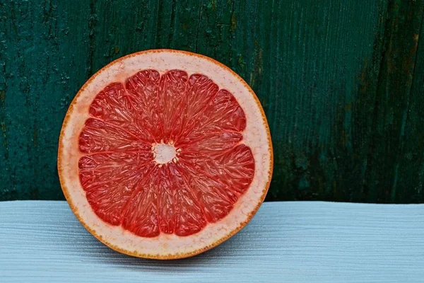 Stück Einer Roten Runden Orange Auf Einem Blauen Tisch Der — Stockfoto