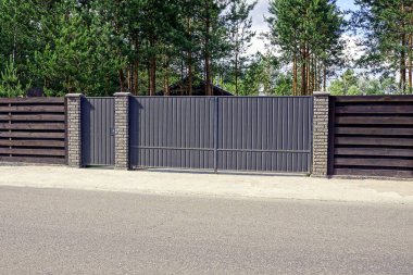 Güneşli bir günde yolun önünde gri çit