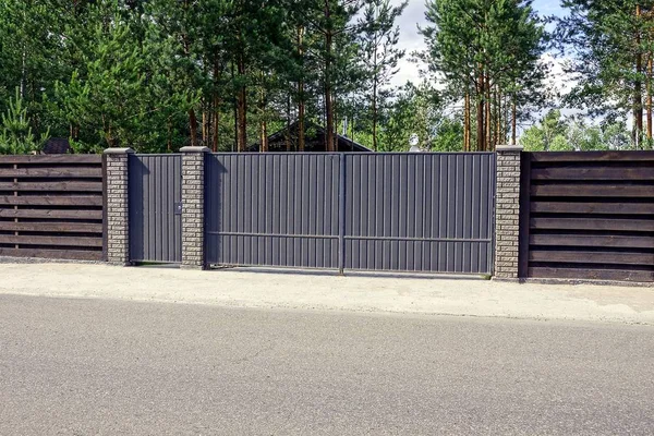 Güneşli bir günde yolun önünde gri çit