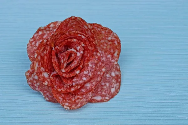 Salame Salsicha Vermelho Forma Uma Flor Fundo Azul — Fotografia de Stock