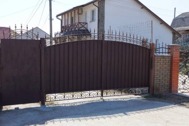 sahte desenli kahverengi metal kapı ve sokakta çit parçası