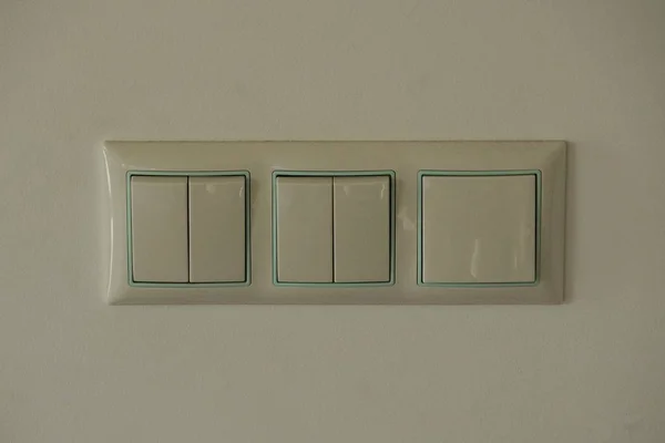 Trzy Szare Przełączniki Tworzywa Sztucznego Białej Ścianie Pomieszczeniu — Zdjęcie stockowe