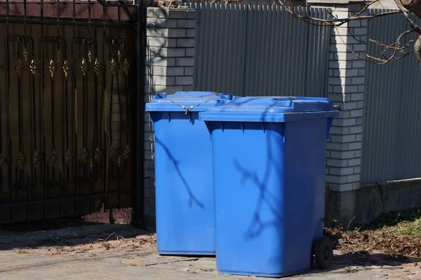 Iki Mavi Plastik Kaplar Çit Duvarının Yakınındaki Sokakta — Stok fotoğraf