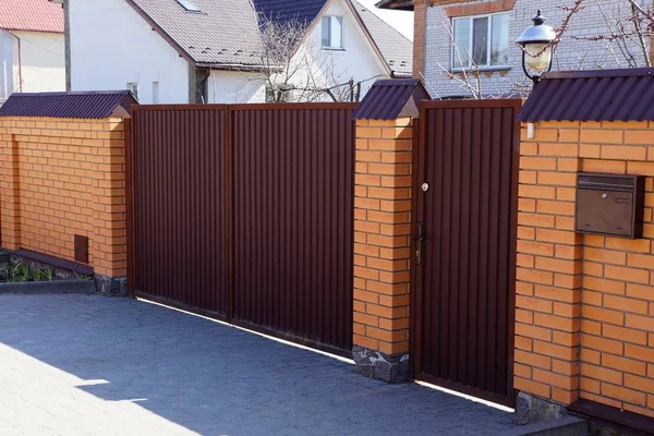 kaldırımda sokakta kahverengi demir kapı ve tuğla çit