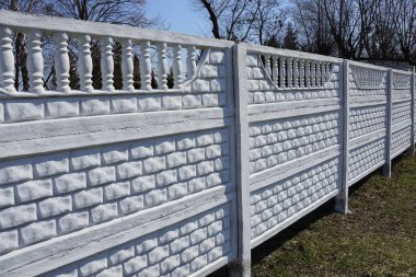 yeşil çim dışında uzun beyaz beton çit