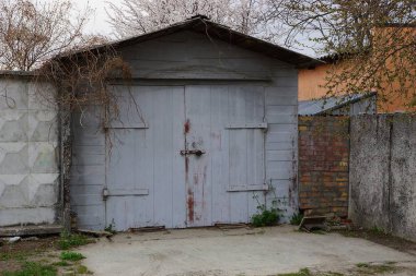 kapalı kapı ve sokakta çit parçası ile eski gri metal garaj