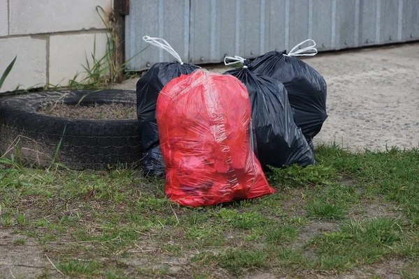 Red Black Plastic Bags Garbage Green Grass — Stock Photo, Image