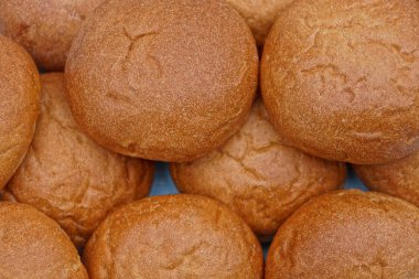 Mavi bir arka plan üzerinde kahverengi yuvarlak çörekler satırları
