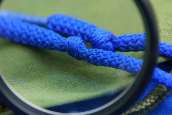 One Black Magnifier Enlarges Two Blue Laces Knots Green Matter — Stock Photo, Image