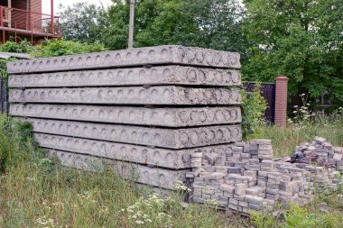 Gri beton bloklar ve evin duvarına yakın çim döşeme