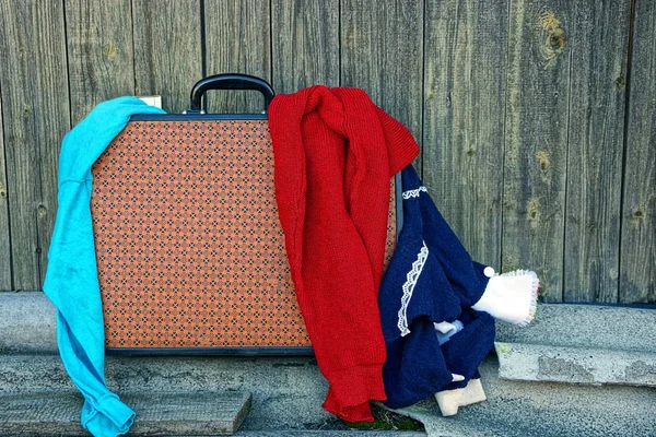 Βαλίτσα Και Ρούχα Κοντά Στον Τοίχο Γκρι — Φωτογραφία Αρχείου