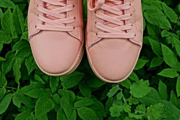 pink sport shoes for women on green grass and leaves outside