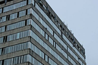 gökyüzüne karşı beton ve pencerelerden yapılmış eski gri beton evin parçası