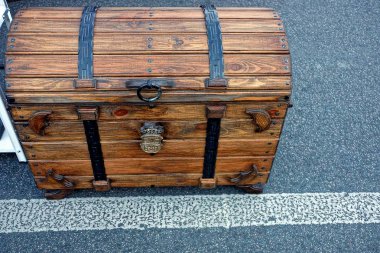 Kahverengi kapalı ahşap göğüs avluda asfalt üzerinde duruyor