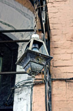 Duvarda asılı bir ampul ile eski demir fener