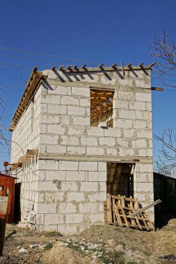 Beyaz tuğla tamamlanmamış ev ile inşaat sitesi