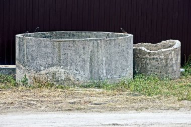 Çitin yanındaki bahçede iki eski beton halka
