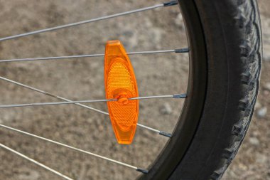 bir bisiklet üzerinde siyah tekerleğin gri metal kollu bir plastik turuncu reflektör