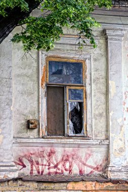 kırılmış cam üzerinde gri bir duvar ile eski pencere