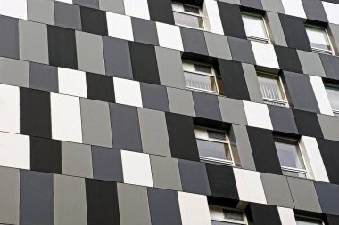 Pencereli modern çok katlı bir binanın siyah ve beyaz duvarı